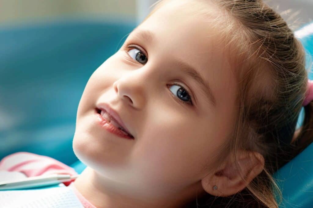 a girl is sitting in the dentist's chair